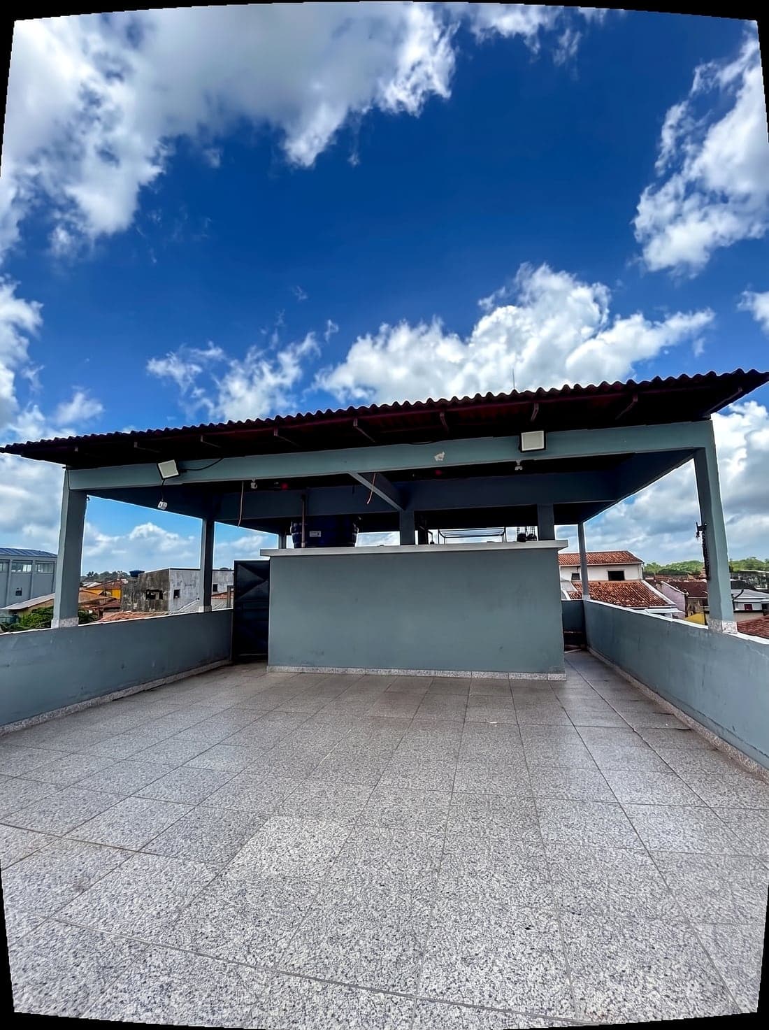 A cobertura do terraço hoje: pérgola de estrutura metálica, balcão de alvenaria e o piso de granito.