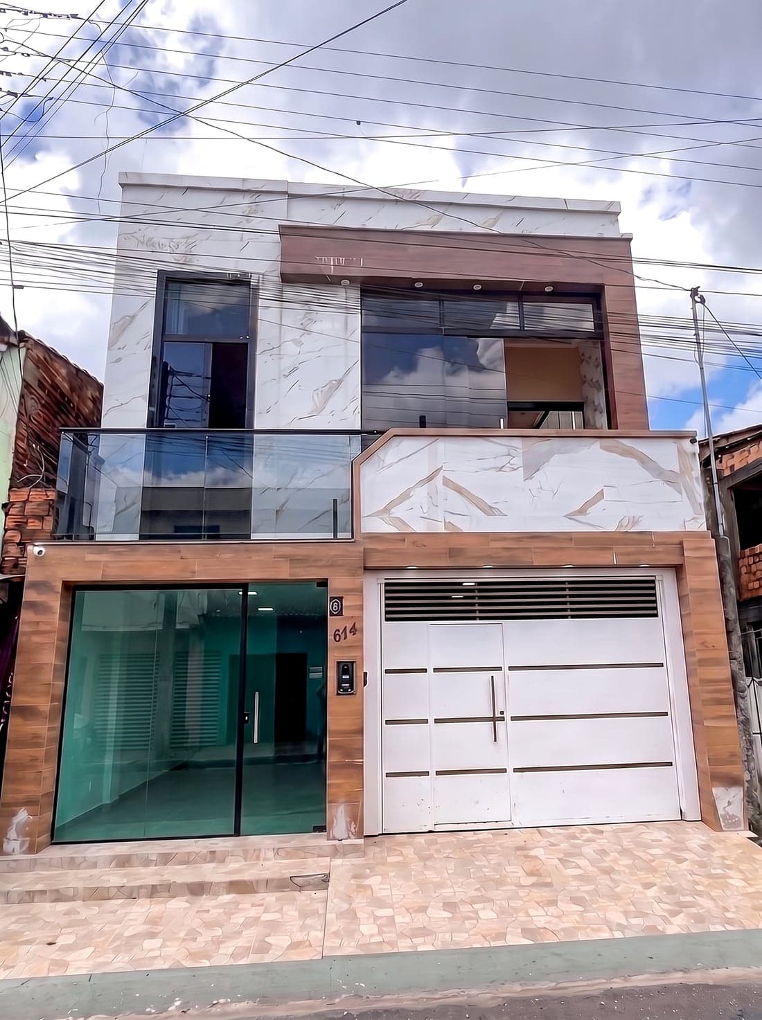 Fachada da casa no Centro de Vigia de Nazaré, com revestimento em pedra e madeira.